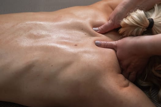 A woman undergoing a massage of the cervical-collar area