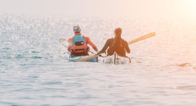 Happy smiling woman in kayak on ocean, paddling with wooden oar. Calm sea water and horizon in background