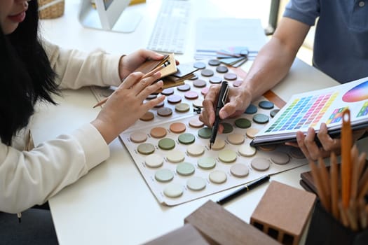 Cropped shot Interior designer helping client choosing colors in swatches palette for apartment renovation.