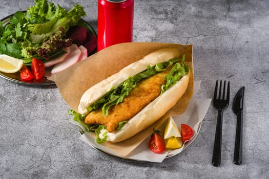 Fried fish sandwich with greens on the stone table. Turkish name Balik Ekmek