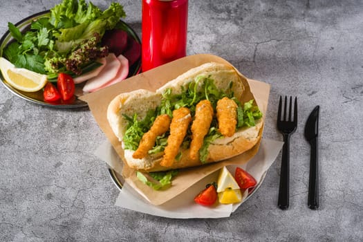 Deep fried shrimp in bread with greens on the side. Shrimp sandwich