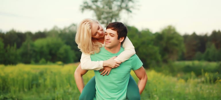 Portrait of beautiful happy smiling young couple in love together hugging in green summer park