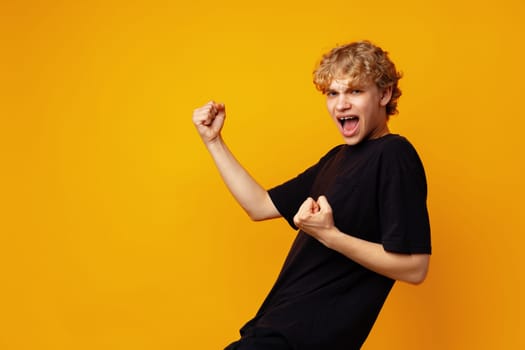 Young handsome man wearing glasses over yellow background very happy and excited doing winner gesture close up