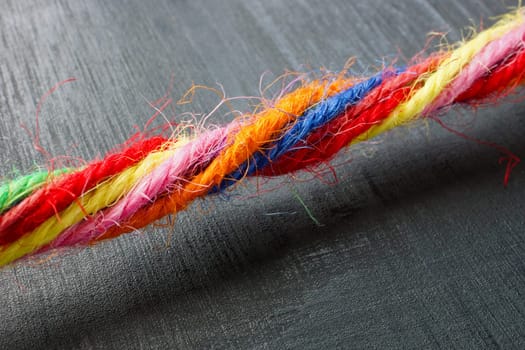 Close-up of a rope made of colored threads as symbol of unity and inclusion.