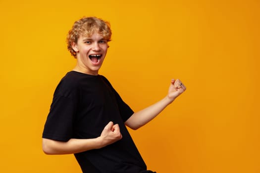 Young handsome man wearing glasses over yellow background very happy and excited doing winner gesture close up