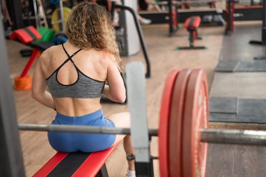 Middle-aged woman sitting on a bench in the gym