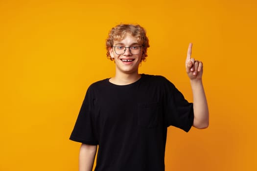 Young caucasian handsome man on yellow background thinking an idea and pointing finger up close up