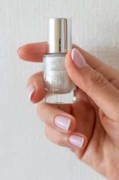 Shot of the beautiful woman's hand holding bottle of nail enamel