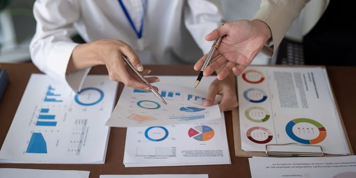 Close up of businesswomen discussing data charts. Concept of teamwork and analysis.