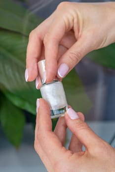 Shot of the beautiful woman's hand holding bottle of nail enamel