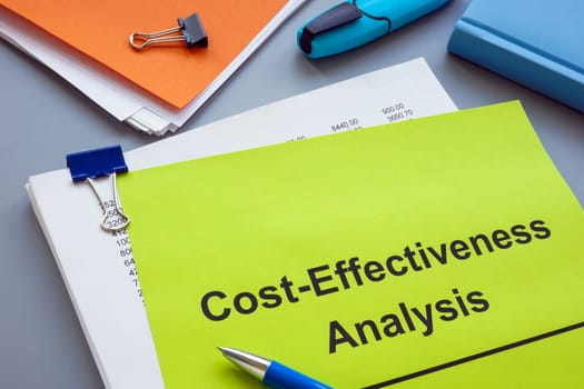 A Stack of documents with cost effectiveness analysis.