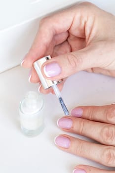 Shot of the beautiful woman's hand holding bottle of nail enamel