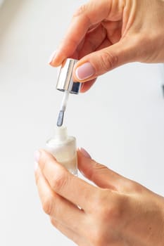 Shot of the beautiful woman's hand holding bottle of nail enamel