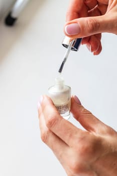 Shot of the beautiful woman's hand holding bottle of nail enamel