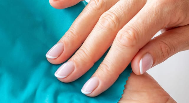 Shot of the beautiful woman's hand holding piece of vivid, bright cloth