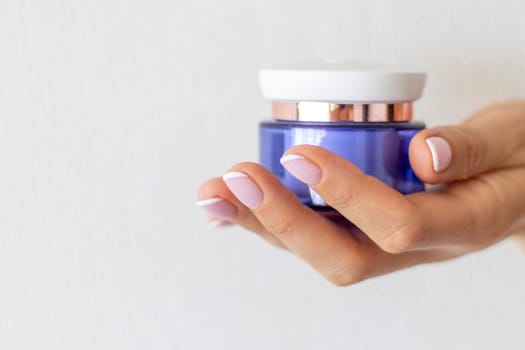Shot of the beautiful woman's hand holding bottle of skin care product.