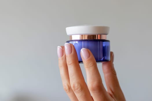 Shot of the beautiful woman's hand holding bottle of skin care product.