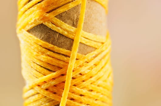 Detail of  yellow thread   on spool, dressmaker at work ,