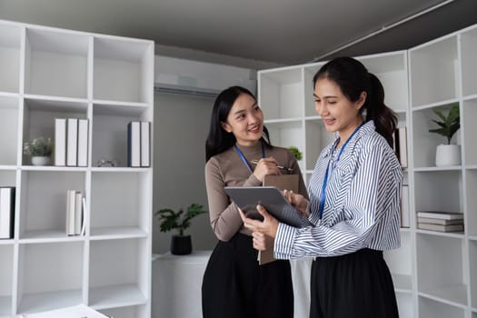 Businesswomen collaborating with digital tablet in office. Concept of teamwork and technology.