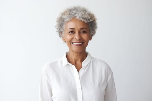 Portrait of beautiful happy smiling african mature woman with gray hair looking at camera on white studio background