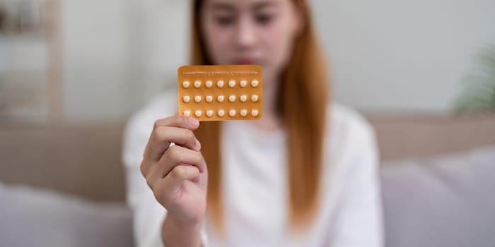 Woman holding a pack of birth control pills. Concept of contraception and reproductive health.