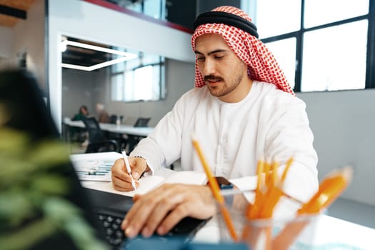 Young successful arab businessman working in the office close up