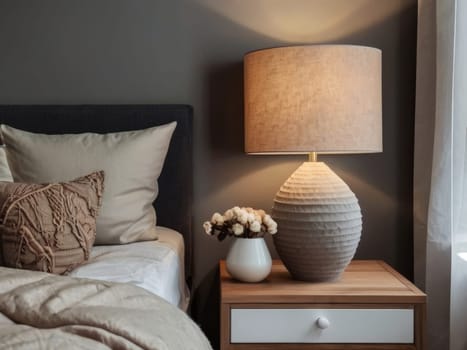 Charming bedside table arrangement with a lamp and blooming flowers, enhancing the serene ambiance of the Scandinavian-style bedroom