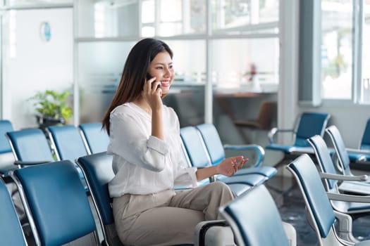 Woman use smartphone while waiting for her flight in airport lounge. travel concept.