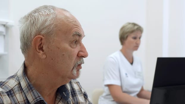 Elderly man at doctor's appointment. Clip. Grandpa is at doctor's appointment. Therapist prescribes treatment for elderly man.