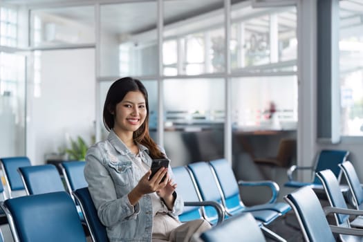 Woman use smartphone while waiting for her flight in airport lounge. travel concept.