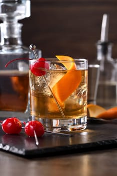 Cocktail Old Fashioned is an old-fashioned sophistication of whiskey and sweet syrup. Served with ice, orange zest and Maraschino cherry. 