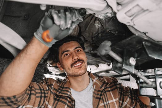 Auto mechanic repairs running gear of a car in car service close up