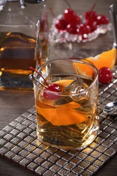Cocktail Old Fashioned is an old-fashioned sophistication of whiskey and sweet syrup. Served with ice, orange zest and Maraschino cherry. 