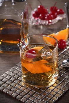 Cocktail Old Fashioned is an old-fashioned sophistication of whiskey and sweet syrup. Served with ice, orange zest and Maraschino cherry. 