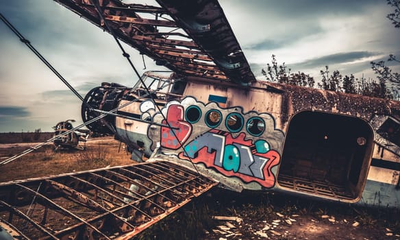 Vovchansk, Ukraine - 15 May 2020: Abandoned destroyed old airplane with colorful graffiti at the airfield