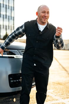 Casual man standing near his luxury car at the parking close up