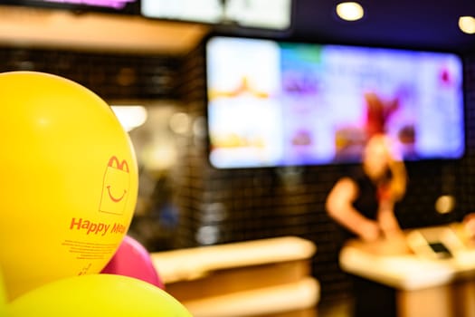 Berlin, Germany - 10 April 2023: advertising of Happy Meal on yellow balloons in McDonald's inside
