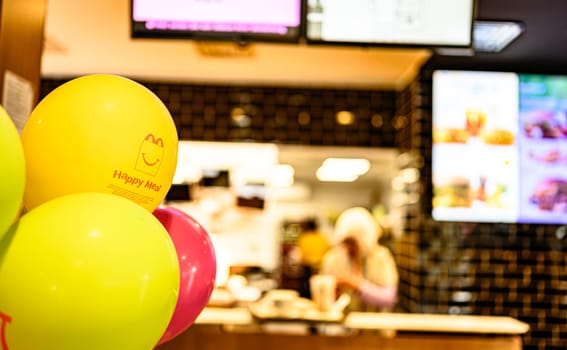 Berlin, Germany - 10 April 2023: advertising of Happy Meal on yellow balloons in McDonald's inside