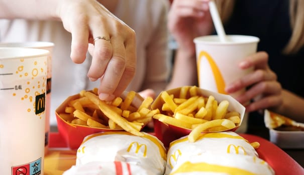 Poznan, Poland - 28 april 2024: Mom And Young Daughter Dining At Mcdonald's