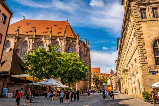 Nurnberg, Germany - 29 August 2022: Old city center square with tourists in Nuremberg, Germany. Historical travel destination in Bavaria region, Europe with beautiful houses and people
