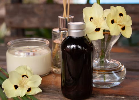 Spa set on wooden table with yellow floral decoration. Aromatherapy concept.