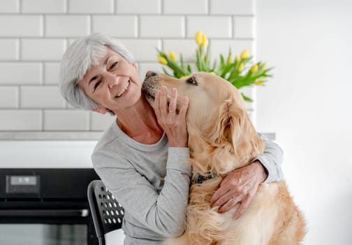 Woman With Grey Hair Enjoys Time At Home With Golden Retriever