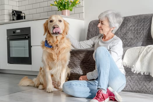 Woman With Grey Hair Enjoys Time At Home With Golden Retriever