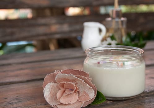 A rustic wooden table with a spa set. Flowers and scented candle