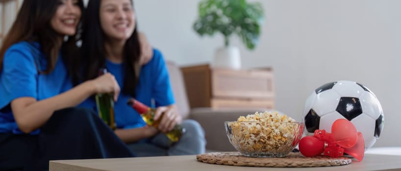 Lesbian couple watching Euro football match at home. Concept cheer and football.