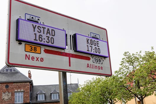 Information board or sign about ferry departures to the Swedish city of Ustad and the Danish city of Koge. Bornholm, Denmark - May 25, 2024