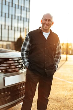 Casual man standing near his luxury car at the parking close up