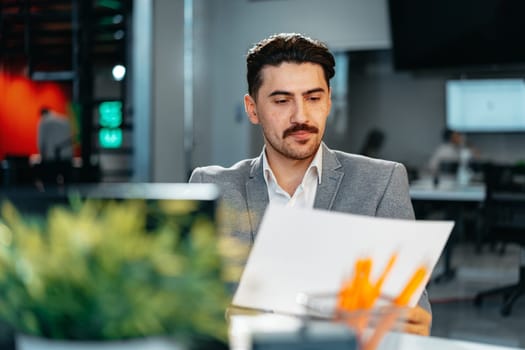 Young arab businessman working at the table in modern office close up