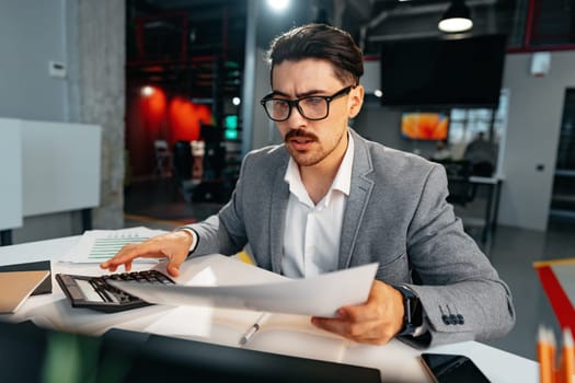 Young arab businessman working at the table in modern office close up