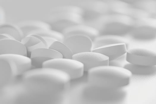 Healthcare concept white pills on table with blue bottle in background for medical use